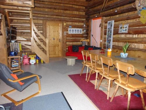 ein Wohnzimmer mit einem Tisch und Stühlen in einer Blockhütte in der Unterkunft Bellahof in Flumserberg