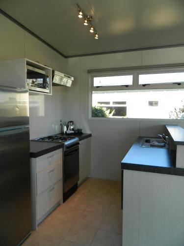 a kitchen with a sink and a stove top oven at Taupo Debretts Spa Resort in Taupo