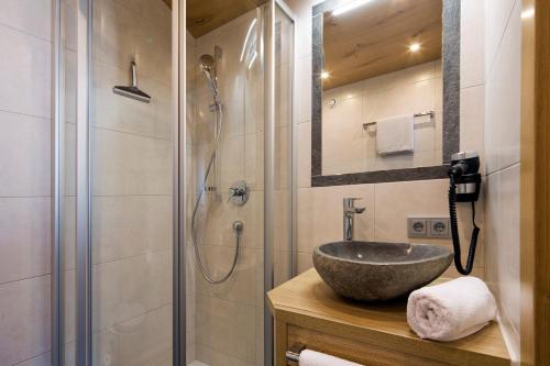 W łazience znajduje się umywalka i prysznic. w obiekcie Hotel Eggerwirt w mieście Söll