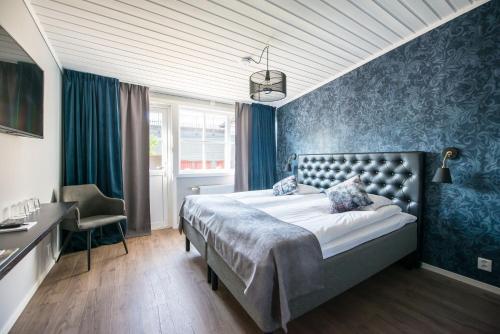 a bedroom with a bed and a desk and a chair at Gylle Hotell & Restaurang Brödernas in Borlänge