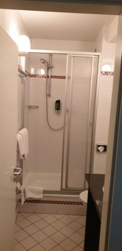 a white bathroom with a shower and a toilet at Osteria-Hotel-Centovini in Cologne