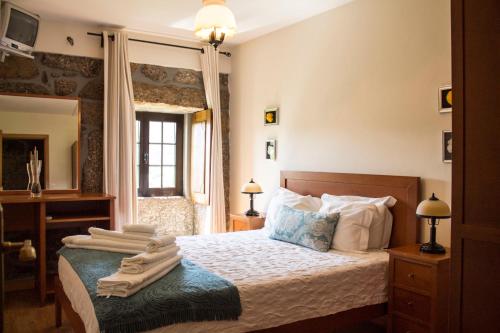 ein Schlafzimmer mit einem Bett mit Handtüchern darauf in der Unterkunft Quinta Do Meira in Braga