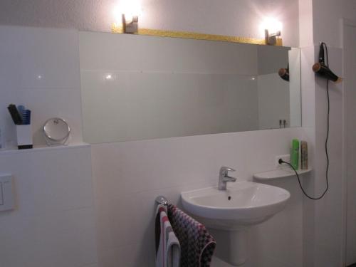 La salle de bains est pourvue d'un lavabo et d'un miroir. dans l'établissement Ferienwohnung Bea in Rheine, à Rheine