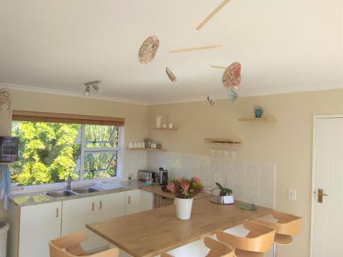a kitchen with a table and chairs and a sink at Spectrum of views near Muizenberg in Lakeside