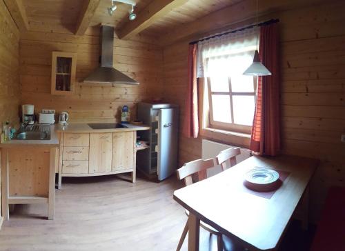a kitchen in a log cabin with a table and a window at Sepp's Ferienhaus in Kirchham