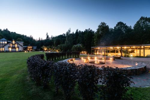 a building with a fire pit in front of it at Boutique Hotel Bersas in Turaida