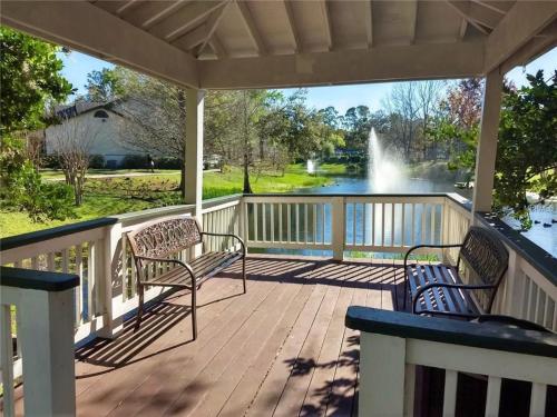 a porch with two chairs and a view of a fountain at #1BR Condo 15Mins To Disney, Universal, Old Town & Parks in Kissimmee