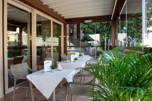 a row of tables on a patio with plants at Hotel Grifone Firenze - Meetings & Spa in Florence