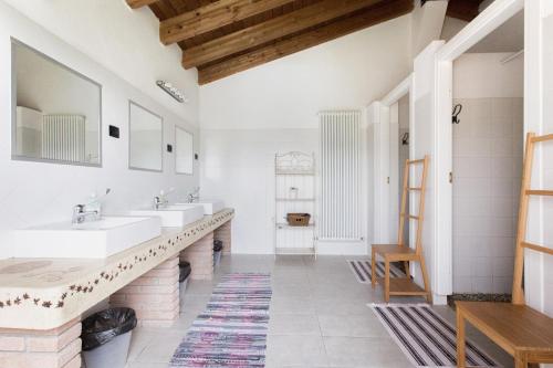 a bathroom with two sinks and two mirrors at Società Agricola Cacigolara in Borgo Val di Taro