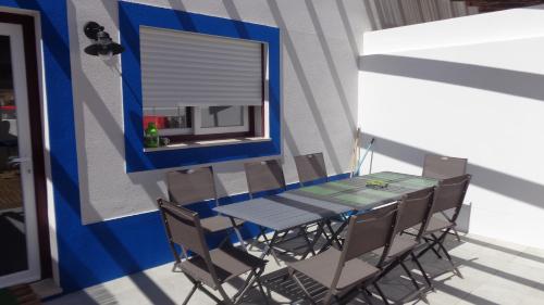 a table and chairs in a room with a window at Casa Férias Melides in Melides