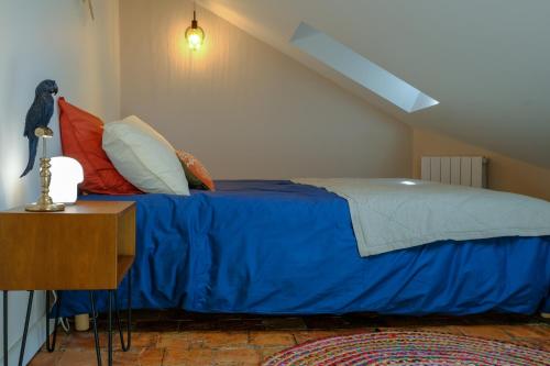 une chambre avec un lit avec des draps et des oreillers bleus dans l'établissement Duplex de charme quartier Opéra Graslin, à Nantes