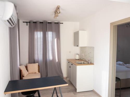 a small kitchen with a table and a sink at KINGS SQUARE Holiday Apartments in Polis Chrysochous