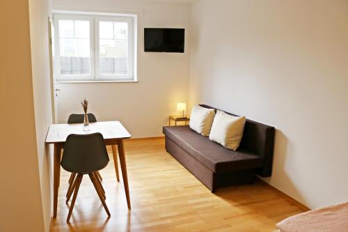 ein Wohnzimmer mit einem Sofa und einem Tisch in der Unterkunft Fewo Burgunder in Hanhofen