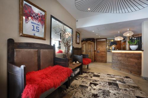a living room with a couch with a red cushion at Hotel 3 Vallées Val Thorens in Val Thorens