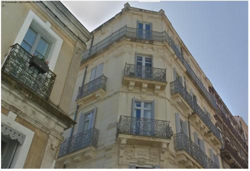 un grand bâtiment avec des balcons sur le côté dans l'établissement Les 7 balcons, Comédie-Corum-Gare, Parking, Spacieux Lumineux Haussmannien, à Montpellier