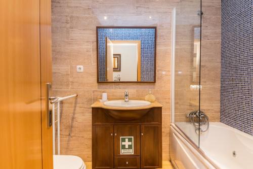 a bathroom with a sink and a toilet and a tub at HouseLuz in Armação de Pêra