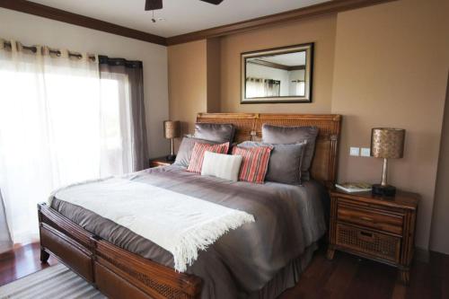a bedroom with a large bed with a mirror on the wall at Emerald Vista Villa in Vieux Fort
