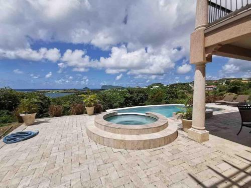 a backyard with a swimming pool and a patio at Emerald Vista Villa in Vieux Fort