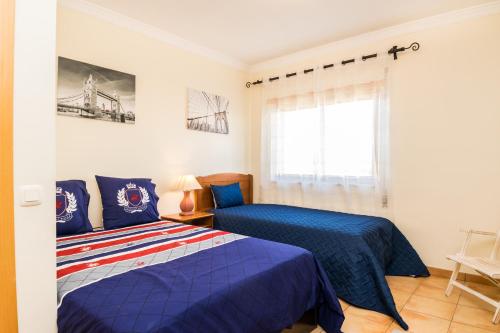 a bedroom with two beds and a window at HouseLuz in Armação de Pêra