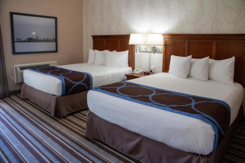 a hotel room with two beds and a television at Super 8 by Wyndham Port Elgin in Port Elgin