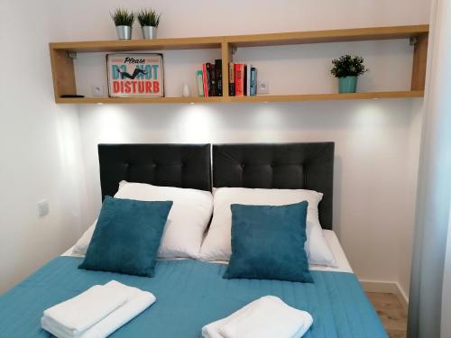 a bedroom with a bed with blue and white pillows at CityLife Business Apartament Centrum in Lublin