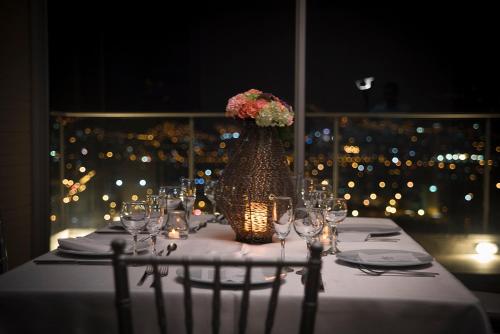 a table with a vase with flowers on it at V Grand Hotel, a member of Radisson Individuals in Medellín