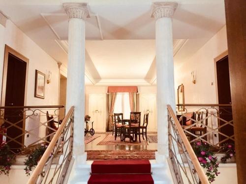 a staircase leading to a living room with columns at Hotel La Loggia in Mestrino