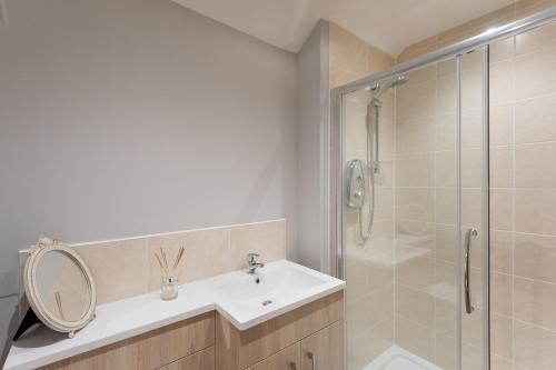 a bathroom with a sink and a shower with a mirror at City Retreat Edinburgh ApartHotels in Edinburgh