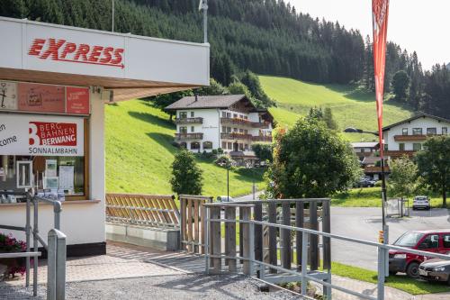 a building in the mountains with a car parked outside at Landhaus Panorama in Berwang