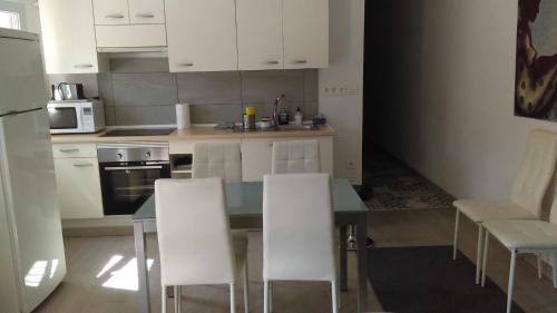 トレモリノスにあるApartamento Torremolinos zona Colinaのキッチン(ダイニングテーブル、白い椅子付)
