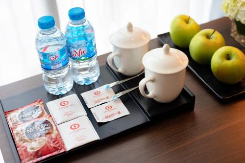 a table with a tray with water bottles and apples at Grand Dragon Hotel Hanoi in Hanoi