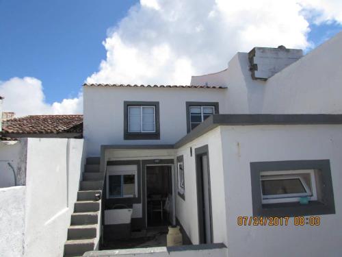 a white house with stairs leading to the door at Casa Benarus in Angra do Heroísmo