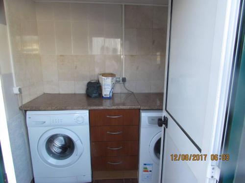 a laundry room with a washing machine and a washer at Casa Benarus in Angra do Heroísmo