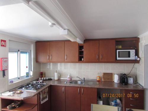 a kitchen with a sink and a microwave at Casa Benarus in Angra do Heroísmo