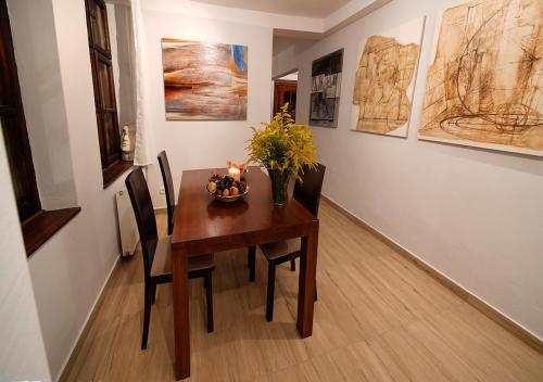 a dining room table with a vase of flowers on it at Ojców Bazar Lwowski in Ojców