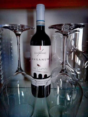 a bottle of wine sitting next to two wine glasses at Il Giardino Di Epicuro in Rocca San Giovanni