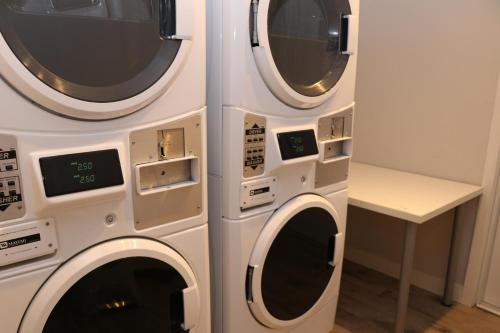 two washing machines are next to each other at A Stylish Stay w/ a Queen Bed, Heated Floors.. #23 in Brookline