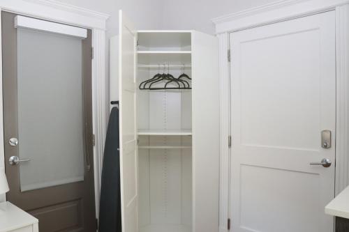 a walk in closet with white doors and shelves at A Stylish Stay w/ a Queen Bed, Heated Floors.. #23 in Brookline