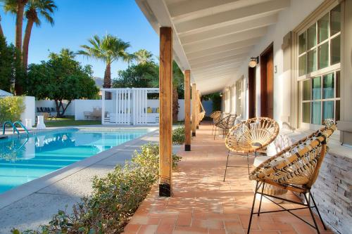 a patio with chairs and a swimming pool at Dive Palm Springs in Palm Springs