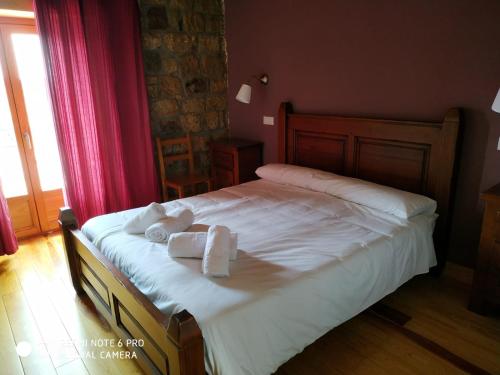 a bedroom with a bed with two towels on it at La casa de la Petra in Quintanar de la Sierra