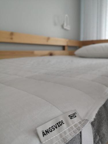 a white bed with a sign on top of it at The Place Astana Hostel in Astana