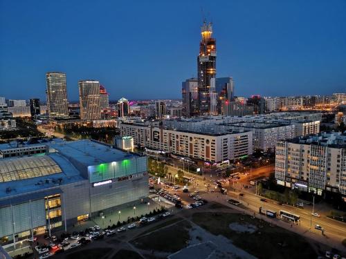 The Place Astana Hostel في أستانا: منظر على أفق المدينة في الليل