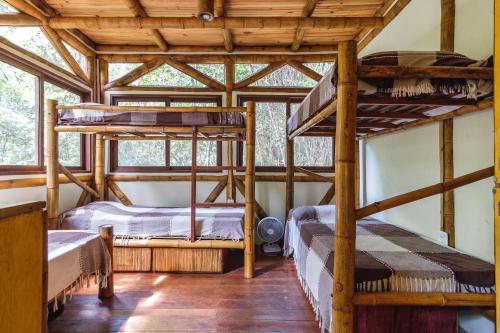 two bunk beds in a room with wooden ceilings at Universo Pol Bamboo Hostel in Morro de São Paulo