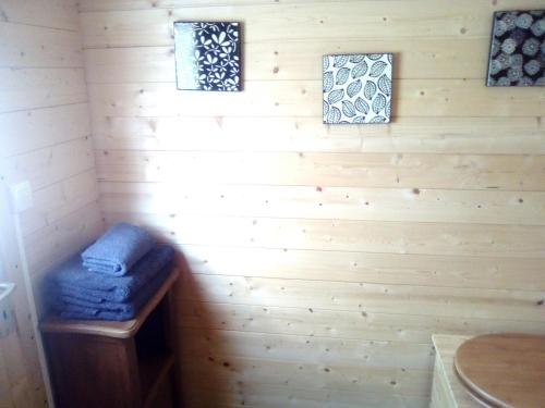 a room in a log cabin with a blue ottoman and two windows at LES TONNEAUX DE L'EURE LOGEMENT INSOLITE in Neuilly