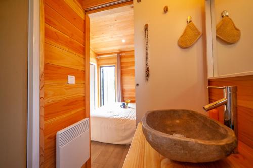 a bathroom with a stone sink and a bedroom at Le Moulin in Martres-Tolosane