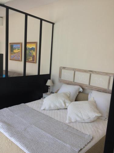 una camera con 2 cuscini bianchi su un letto di L'ATELIER JONQUERETTES a Jonquerettes