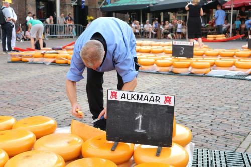 a man bending overront of a display of cheese at Grand Hotel Alkmaar in Alkmaar