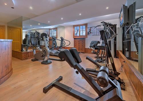 - une salle de sport avec plusieurs tapis de course et vélos d'exercice dans l'établissement Alphotel Taller Wellness & Sport, à Folgarida