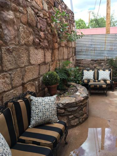 a patio with couches and a stone wall at Bisbee Brownstone Suites in Bisbee