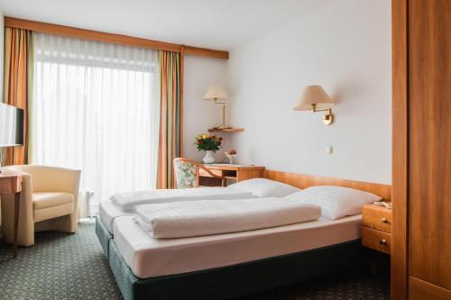 una camera d'albergo con letto e sedia di Attergauhof a Sankt Georgen im Attergau